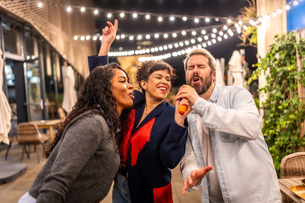 Karaoké en équipe sur une terrasse illuminée